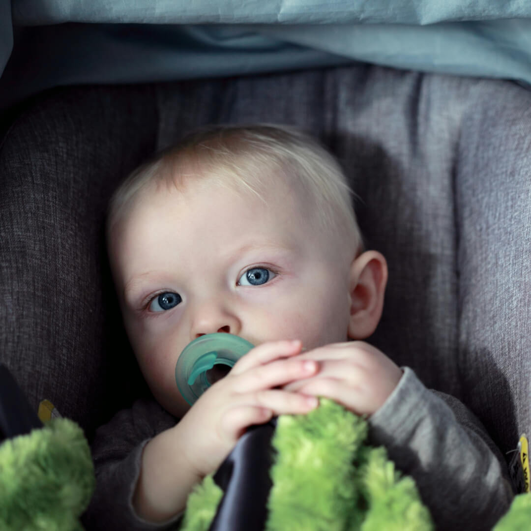 Kind im Kindersitz während der Fahrt mit Flughafentaxi Wien - Fluglide